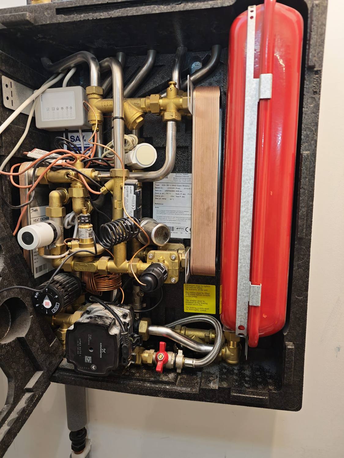 A Gemina Termix unit with the cover off, showing the plate heat exchangers, the circulating pump, actuators and the red expansion vessel